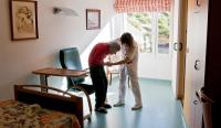 Nurse Woman Helping Senior With Walker