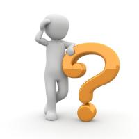 Cartoon person scratching head and standing next to question mark.